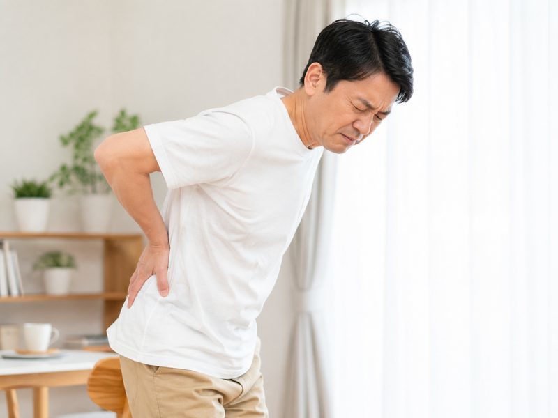 腰椎椎間板ヘルニアでつらそうな男性のイメージ